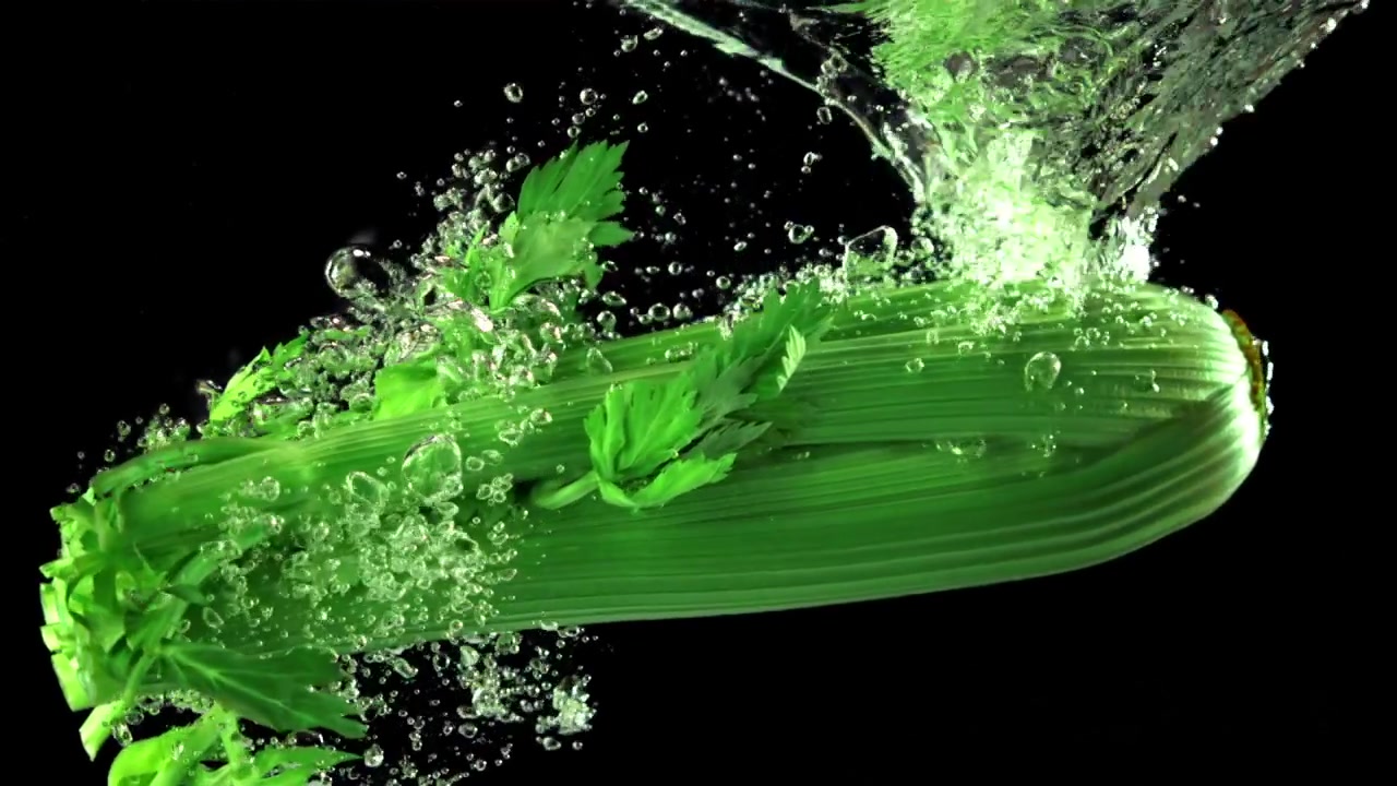 Fresh Green Celery Dropping into Water with Bubbles