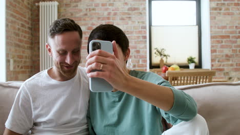 pareja haciendo videollamada en el sofá