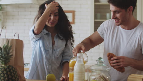 Happy-couple-preparing-breakfast-at-home