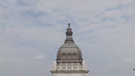 low-angle view of the cross on the tip of a basilica tower against the sky in the background