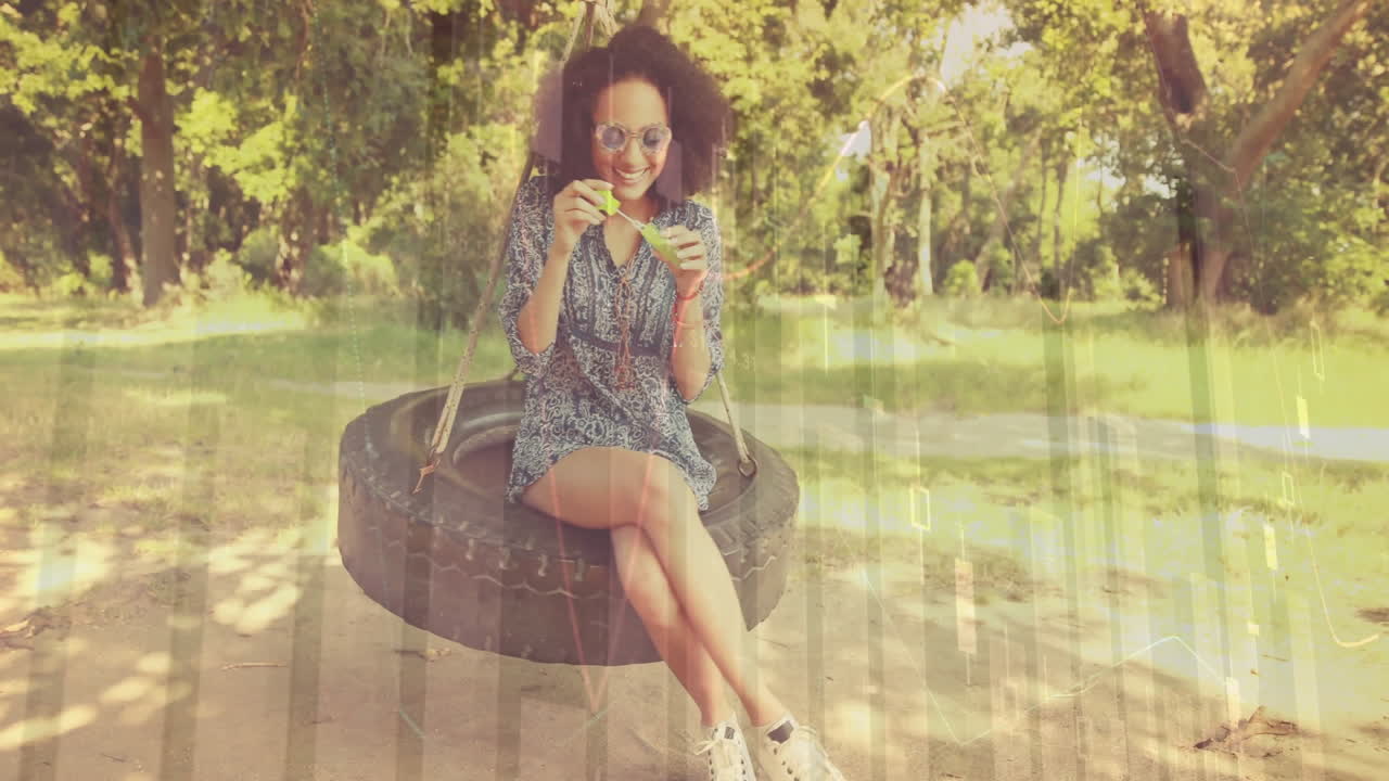 animación de procesamiento de datos financieros sobre mujer afroamericana soplando burbuja de jabón en el parque