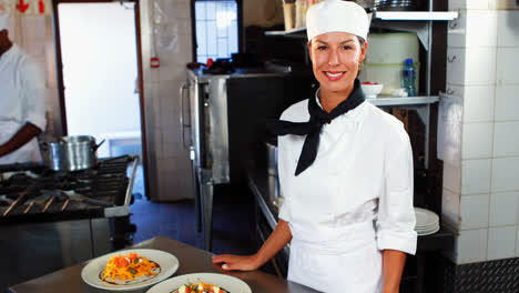 chef sonriente de pie en el mostrador de la cocina