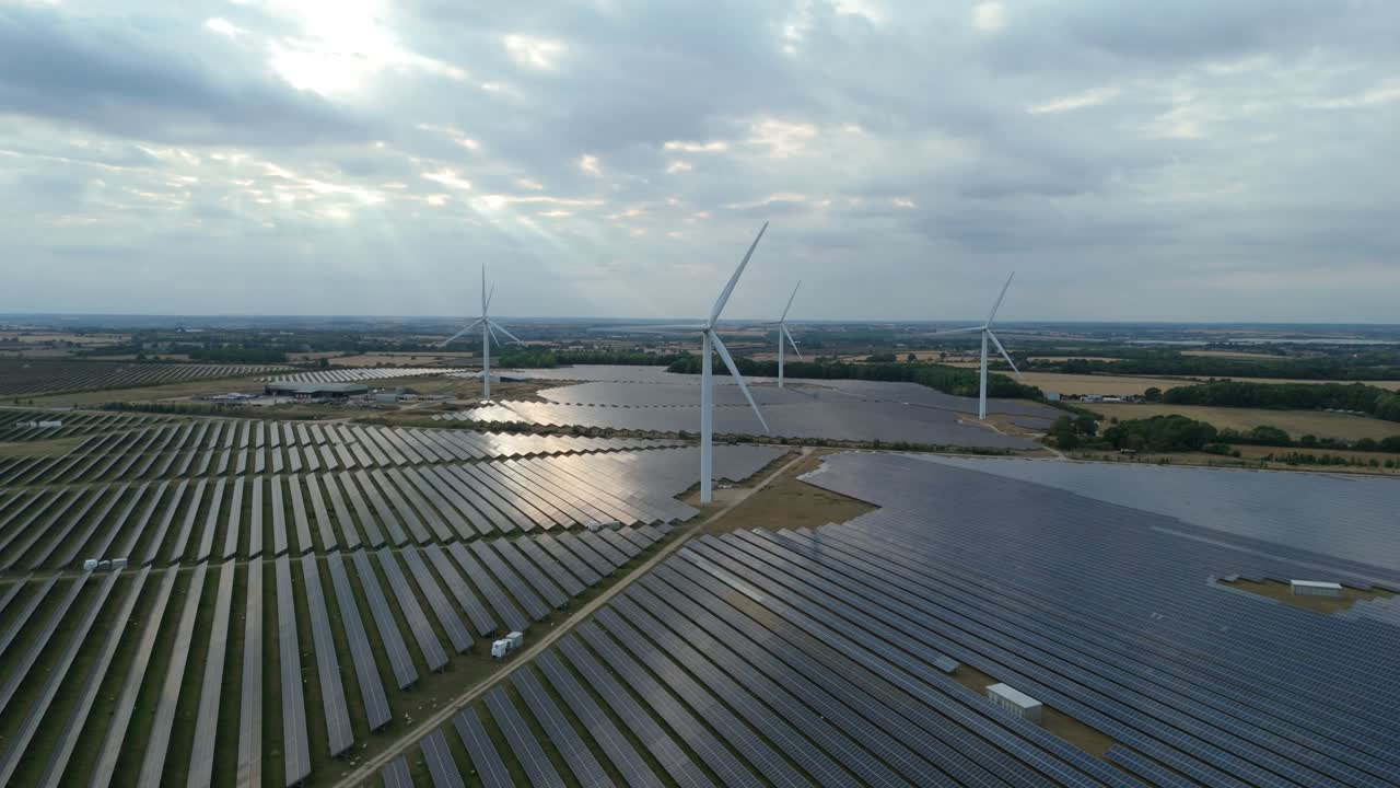 Aerial perspective of large renewable energy facility with wind turbines and solar arrays at sunset in Wellingborough United Kingdom