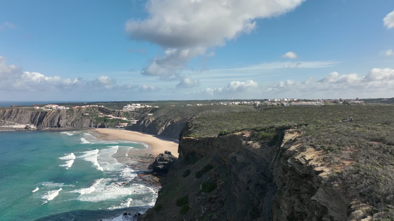 청록색 물이 있는 아름다운 만을 향해 햇볕이 잘 드는 절벽을 따라 날아가는 공중 샷