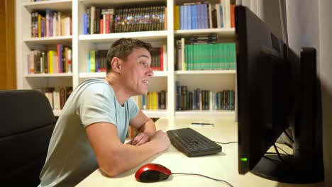 man reacting and interacting with a computer at his desk