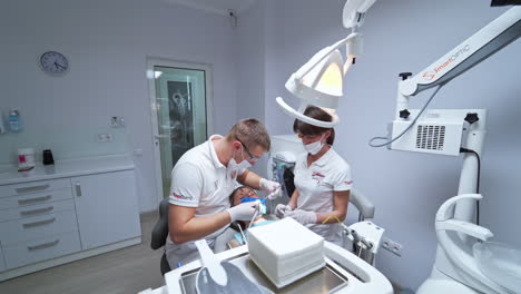 nurse gives the doctor some toothpaste. male dentist prepared to perform professional teeth cleaning.