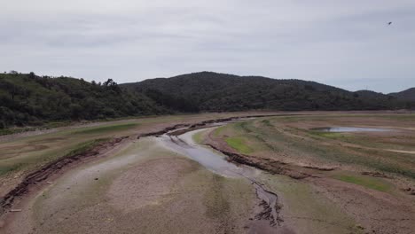 Luftaufnahme-Des-Flusses-Arade-Mit-Niedrigem-Grundwasserspiegel-Und-Waldbäumen-Im-Hintergrund-In-Der-Nähe-Von-São-Bartolomeu-De-Messines-In-Portugal