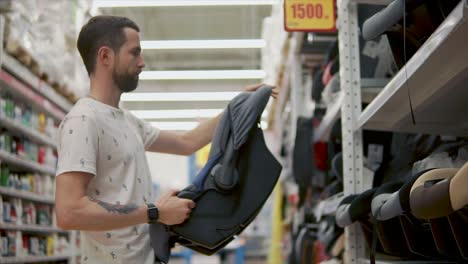 hombre comprando un asiento de coche para bebé en una tienda