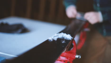 slow motion shot of a person scraping wax off of skis