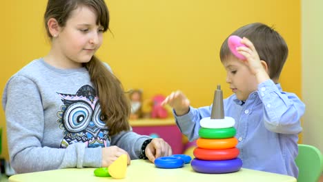 niños hermosos jugando con pirámides de plástico
