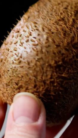 person cutting a kiwi fruit