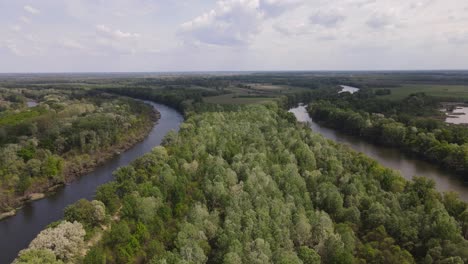 aerial view over section of tisza river in hungary winding through forest