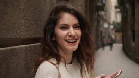 shocked and happy woman looking at camera while holds cellphone