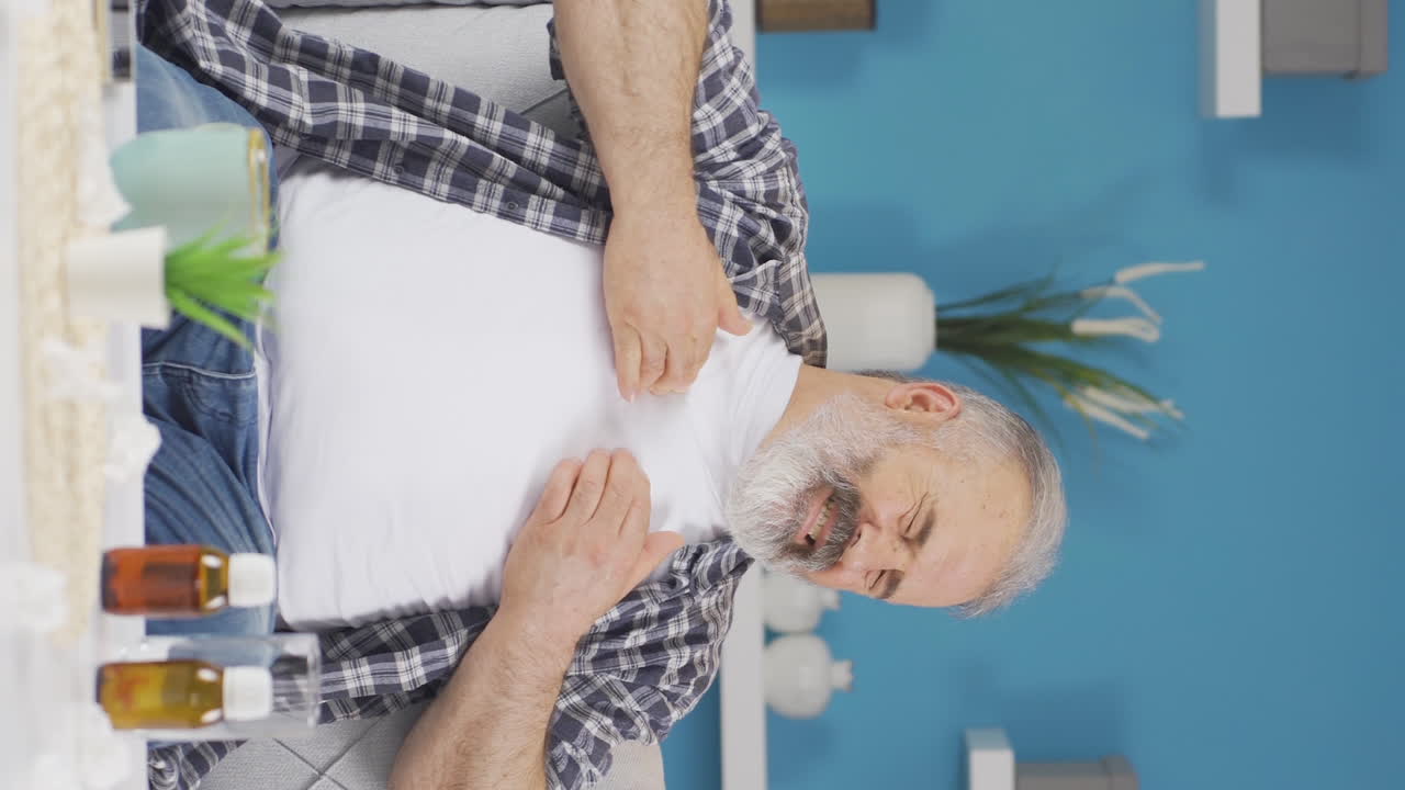 video vertical de un anciano con dolor en el pecho.