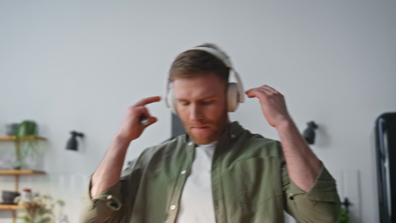 Earphones guy cooking lunch at home kitchen closeup. Relaxed man enjoying music