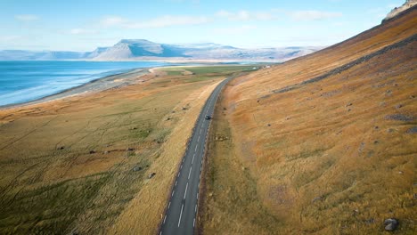 Autofahrende-Autobahn-Mit-Blick-Auf-Das-Meer-Und-Die-Berge-Island-Nach-Drohnenaufnahme