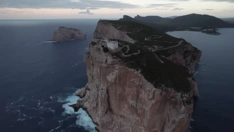 Cabo-Caccia,-Cerdeña:-Vista-Aérea-Acercándose-Al-Faro-De-Este-Famoso-Cabo-En-La-Isla-De-Cerdeña-Y-Durante-La-Puesta-De-Sol