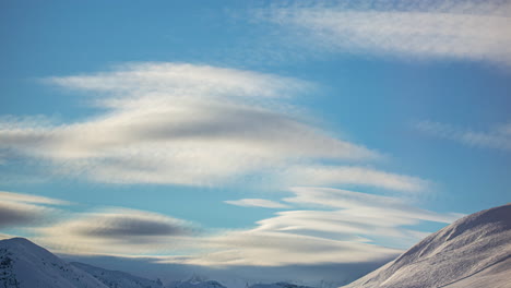 fluffy clouds rolling above mountain landscape, time lapse view