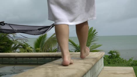 walking behind lady slow motion on garden beach