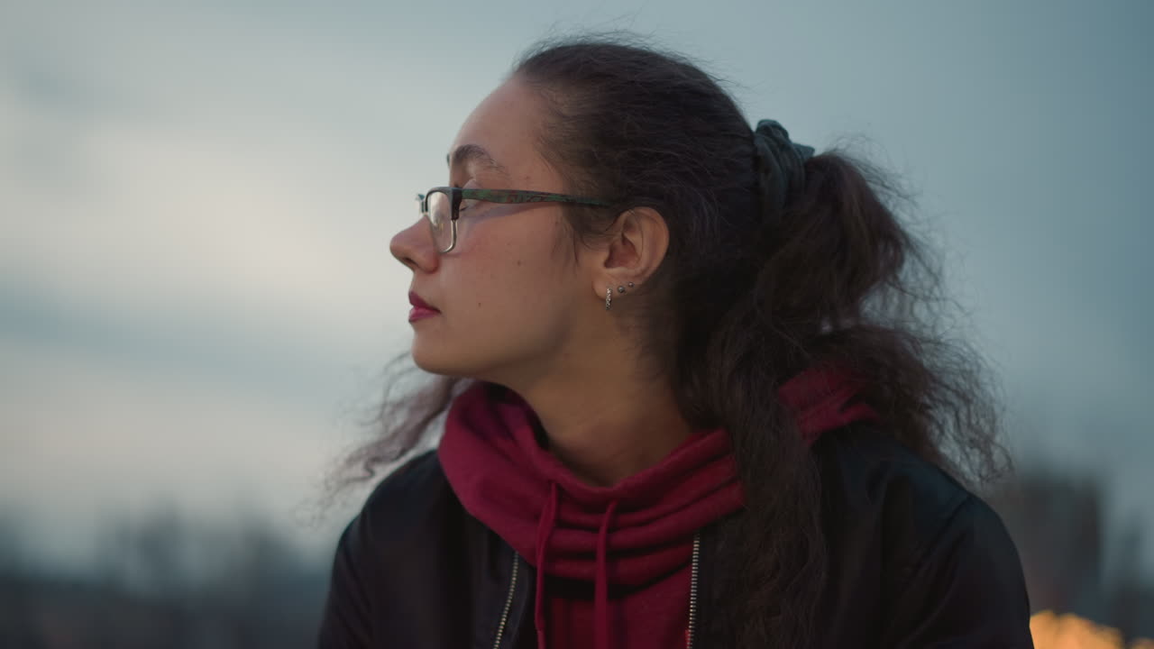Calm Scene Of Person Pondering At Dusk, Serene Individual Lost In Thoughts During Evening City Glow, Tranquil Portrayal Of Someone Contemplating Urban Twilight While Wearing Spectacles