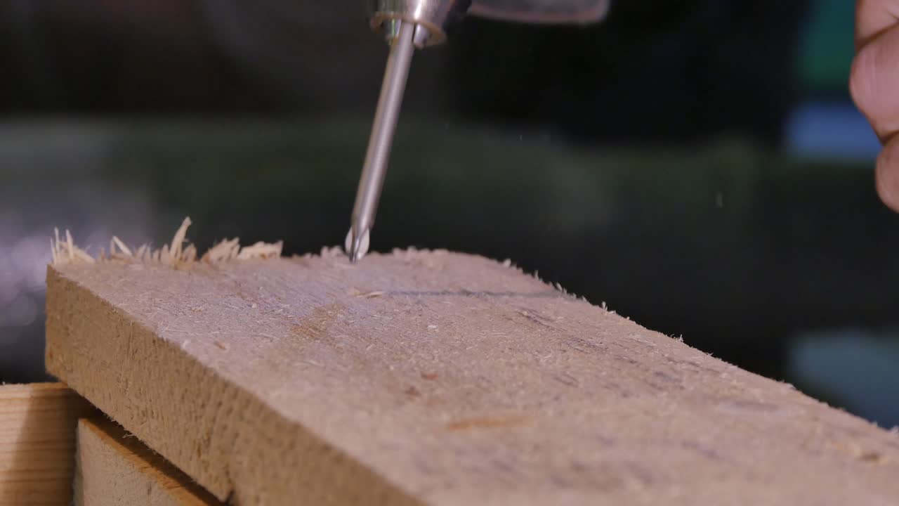 usando un destornillador y un taladro eléctrico para atornillar la madera