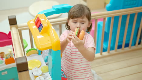 Cute-Little-Girl-Show-Toy-Burger-While-Playing-at-Home