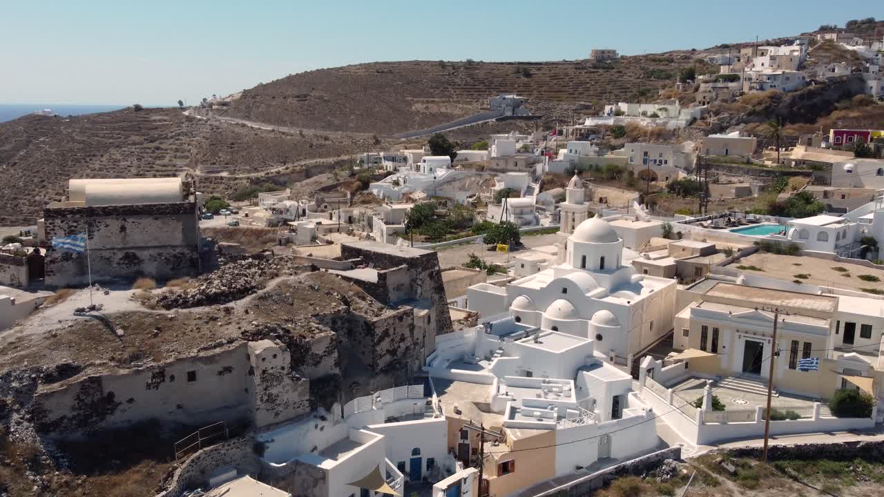 castillo de akrotiri con bandera griega y el pueblo de akrotri, santorini