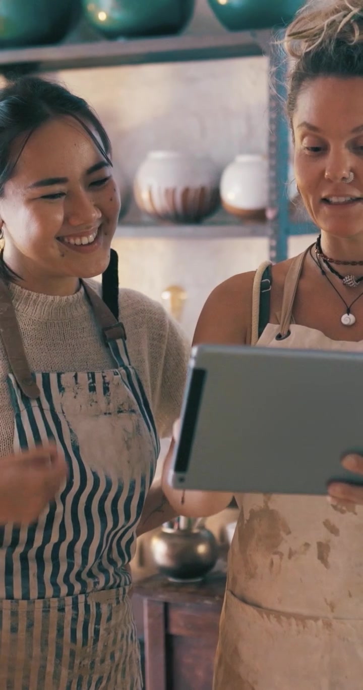 Due Ceramiste Discutono di Progetti su un Tablet in uno Studio