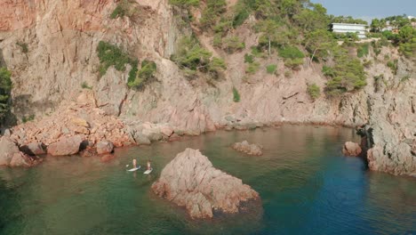 Fit-women-floating-on-paddle-board-in-sea