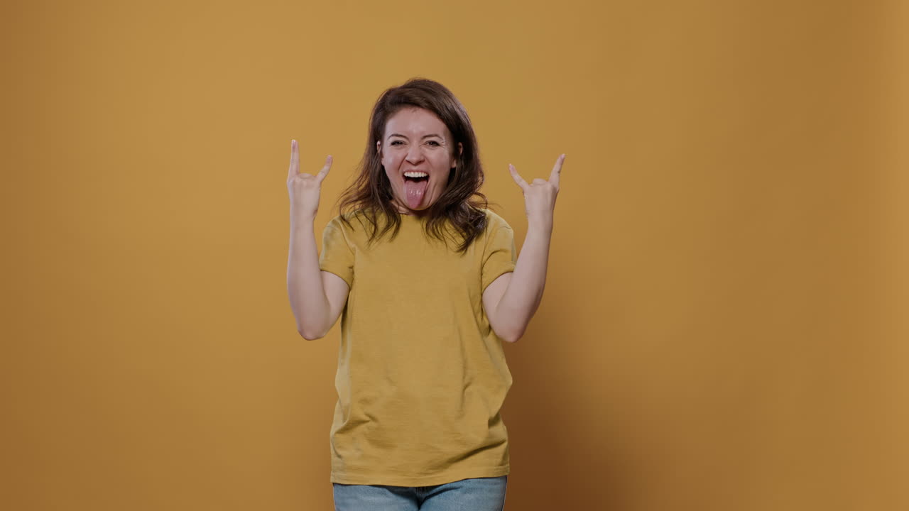 Woman expressing joy with rock on hand gesture