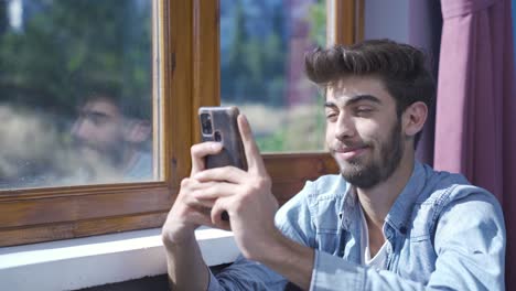 Man-texting-with-happy-expression.