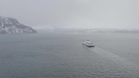 aerial view of ferry cruising from olderdalen to lyngseidet on foggy kaafjord, norway - drone shot