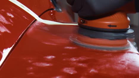 detailing a red sports car with a red polishing machine