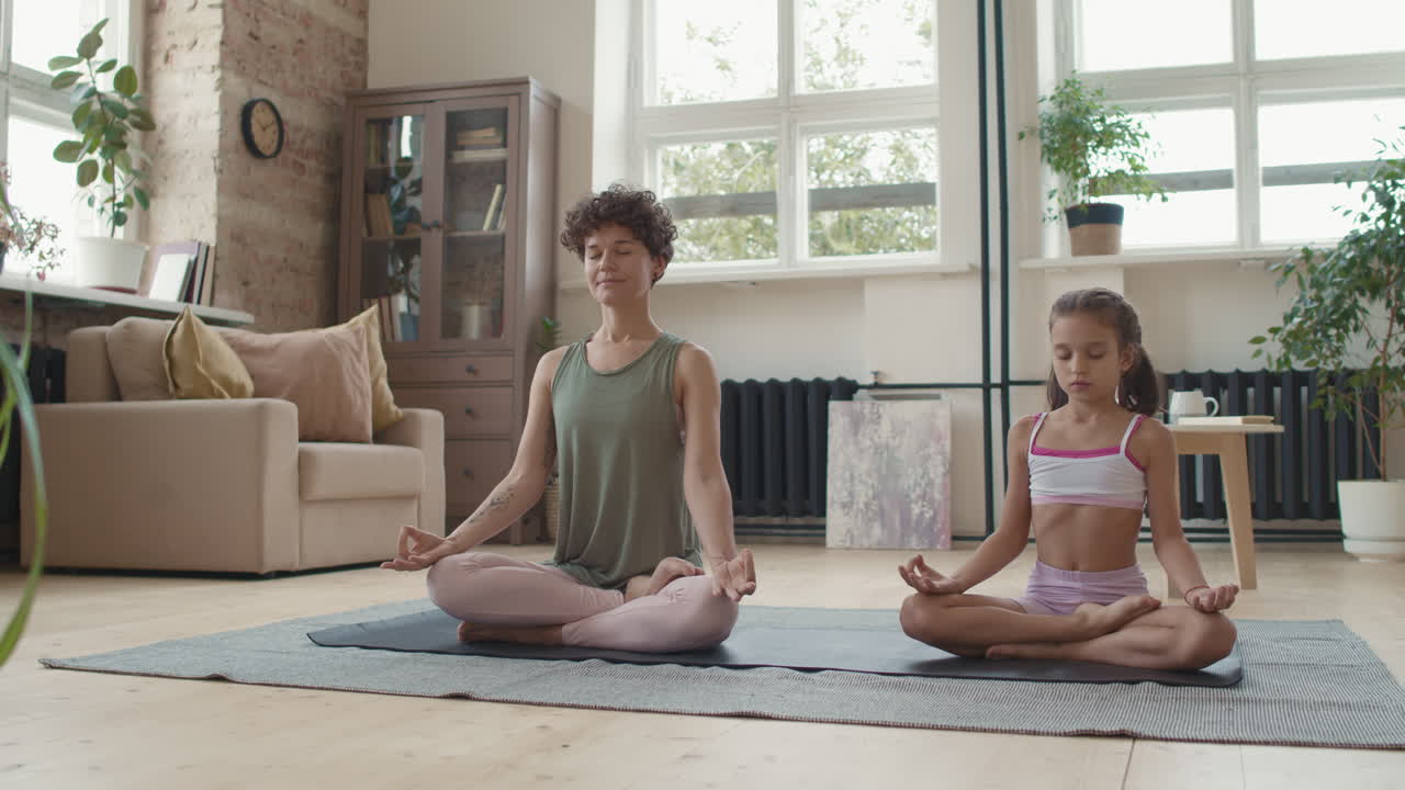 madre e hija practicando yoga en casa