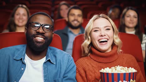 happy diverse couple laughing at movie theater