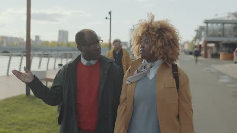 african american colleagues walking outdoors and chatting