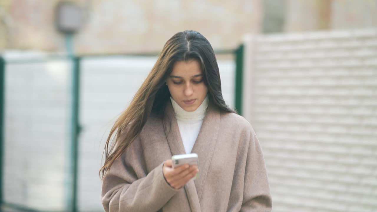 Donna che cammina e usa uno smartphone