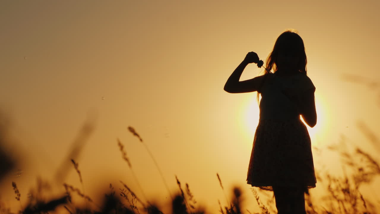 niño despreocupado jugando con pompas de jabón al atardecer de verano y concepto de infancia feliz