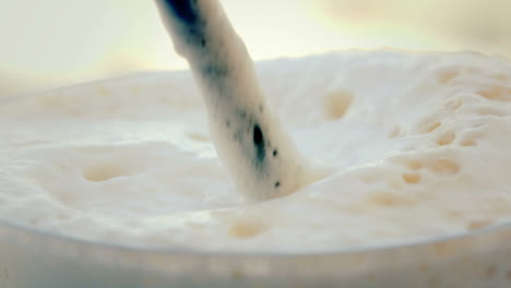 stirring up white foam of coffee