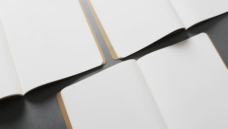 close up de libros en blanco abiertos con espacio de copia en fondo gris en cámara lenta