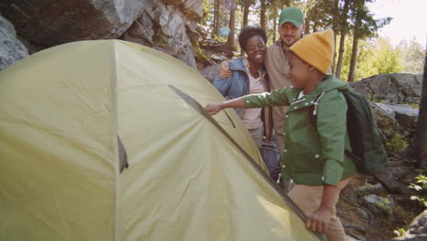 padres multiétnicos felices acampando con su hijo