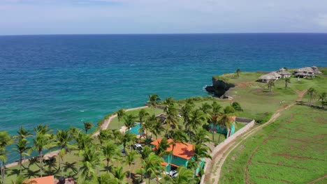 Villas-Al-Borde-De-Un-Acantilado-En-El-Caribe,-Cocoteros-Y-Agua-Azul-Turquesa-Caracterizan-La-Parte-Sur-De-La-República-Dominicana