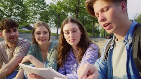 grupo de estudiantes caucásicos que estudian fuera del campus universitario