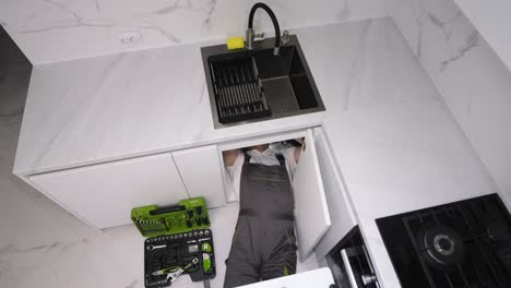 plumber repairing kitchen sink