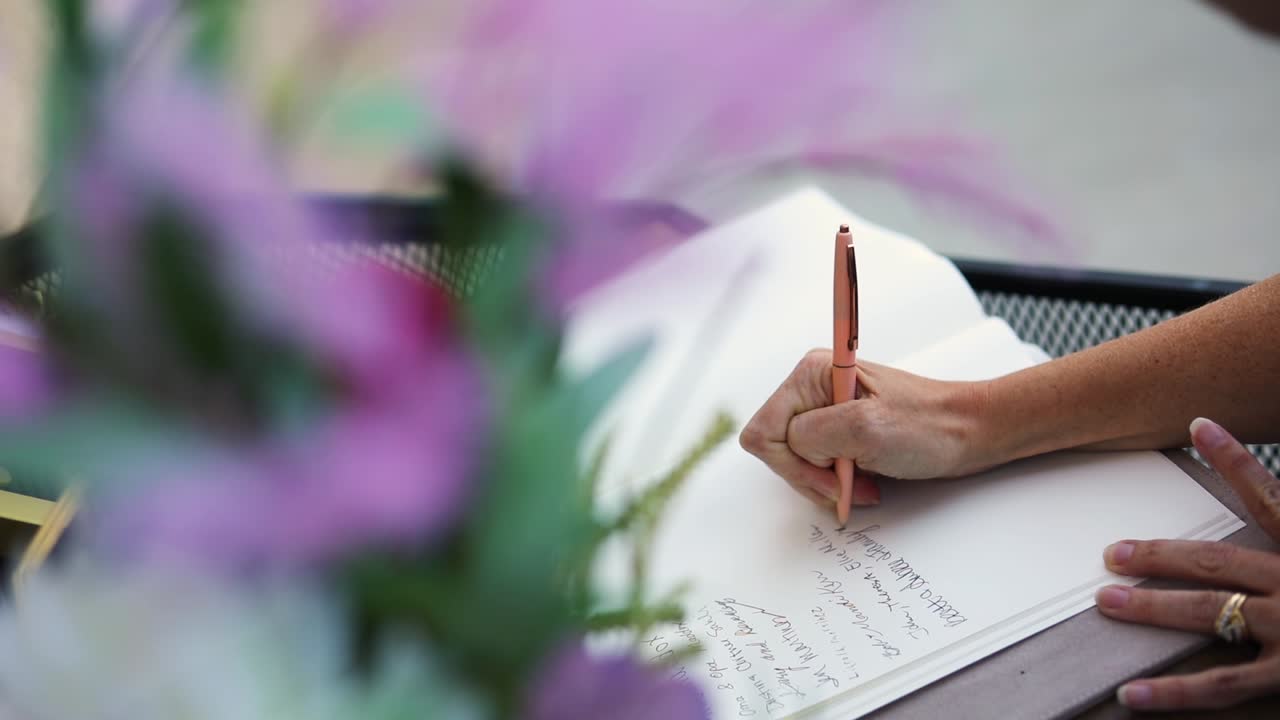 Slow Motion shot of a person signing a guest book at a wedding-marriage reception