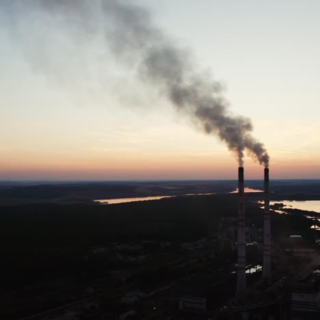 factory tubes on the sunset background. smoke from the pipes. pollution concept. video from the air.