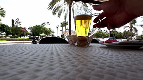 25 fps closeup shot of a beer glass being picked up from the table and kept back on it