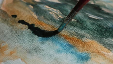 artist painting with watercolor paint, close up of brush