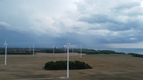 Wind-turbines-in-eolic-park-under-a-cloudy-sky,-aerial-orbiting-view