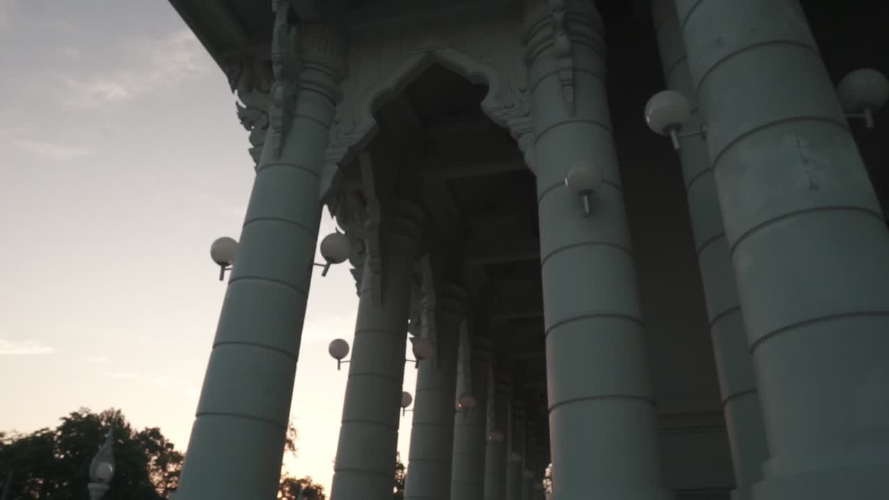 Architettura di un grande tempio con colonne ornate e sentieri al tramonto